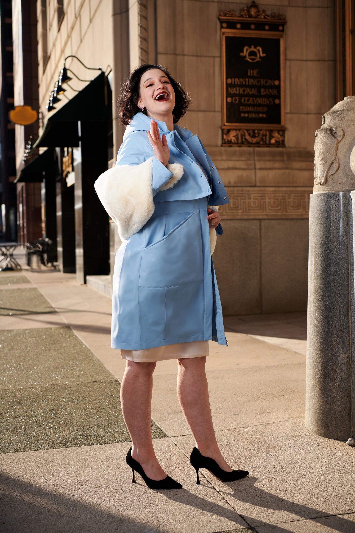woman in blue rain jacket and heels with vegan fur stole marilyn monroe inspired